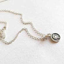 Load image into Gallery viewer, A silver 925 medallion necklace with a spiral design, attached to a silver chain laid out on a white surface.