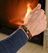 Load image into Gallery viewer, Hand wearing a bracelet with a fireplace in the background