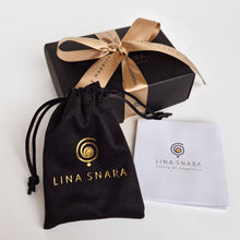 Load image into Gallery viewer, Lina Snara packaging with black drawstring bag, black box with gold ribbon, and white card on a white background