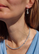 Load image into Gallery viewer, A beaded necklace with light blue aquamarine stones and a handmade silver medallion with a spiral design.top.